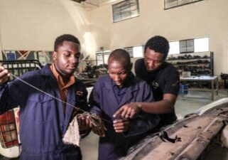 Transparency Auto Workers Cooperative Members inspecting a car's oil level.